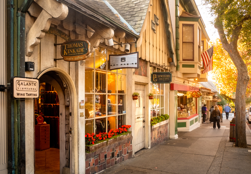 Quaint shops along sidewalk on a sunny day. 